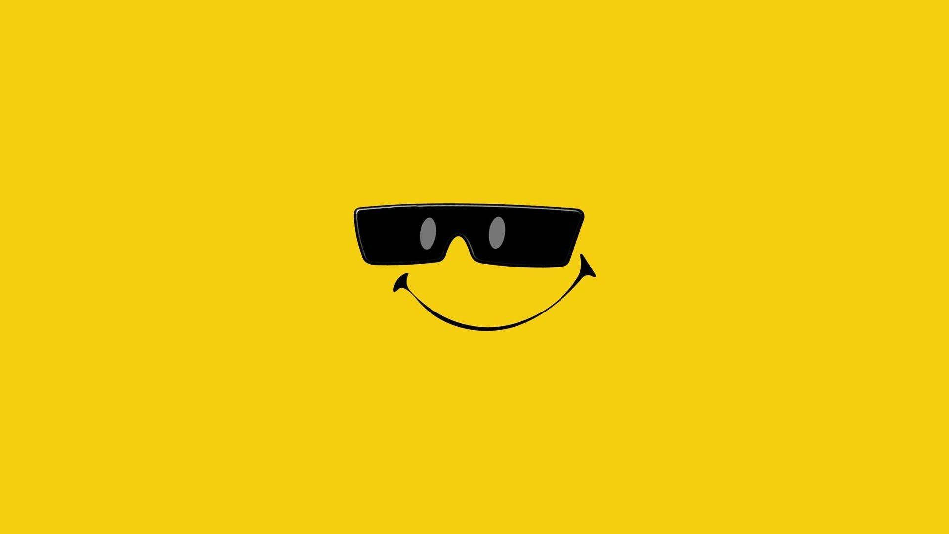 Smile 桌布 壁紙 — 一個極簡黑色笑臉戴著太陽眼鏡，居中在純黃色背景上。