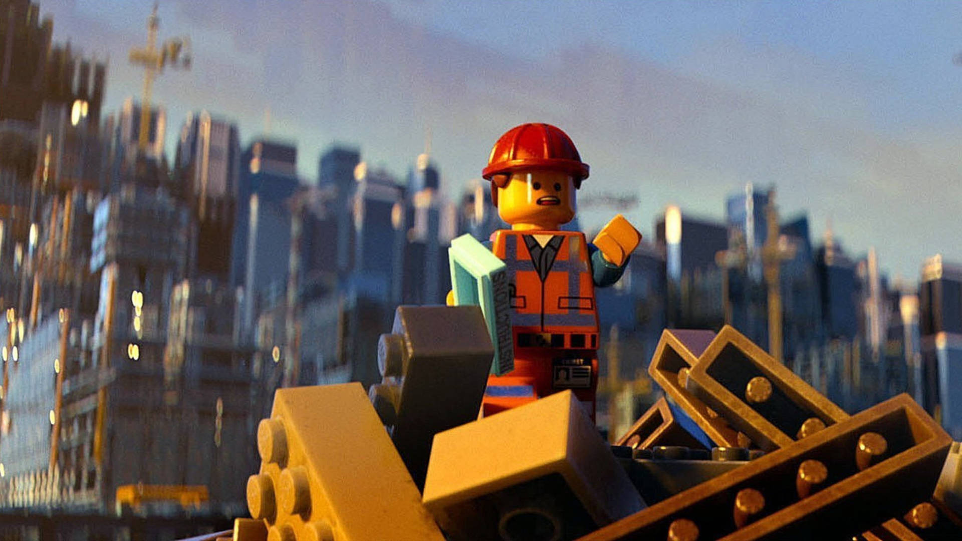 Lego 桌布 壁紙 — 一個樂高建築工人站在磚塊上，背後是夕陽下模糊的城市天際線。