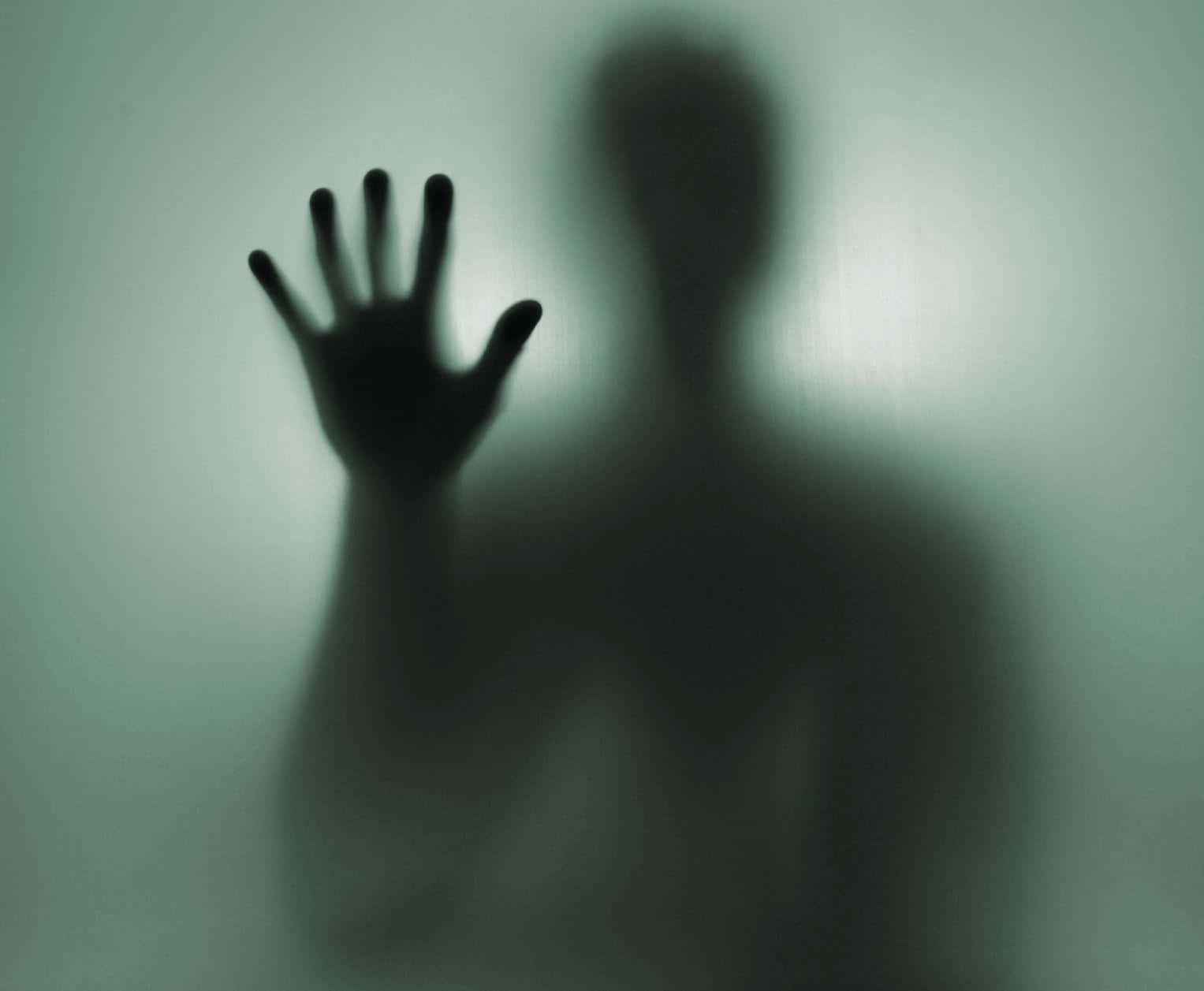 shadow 桌布 壁紙 — 一個模糊的人影在詭異的綠光中將手按在起霧的玻璃窗上。