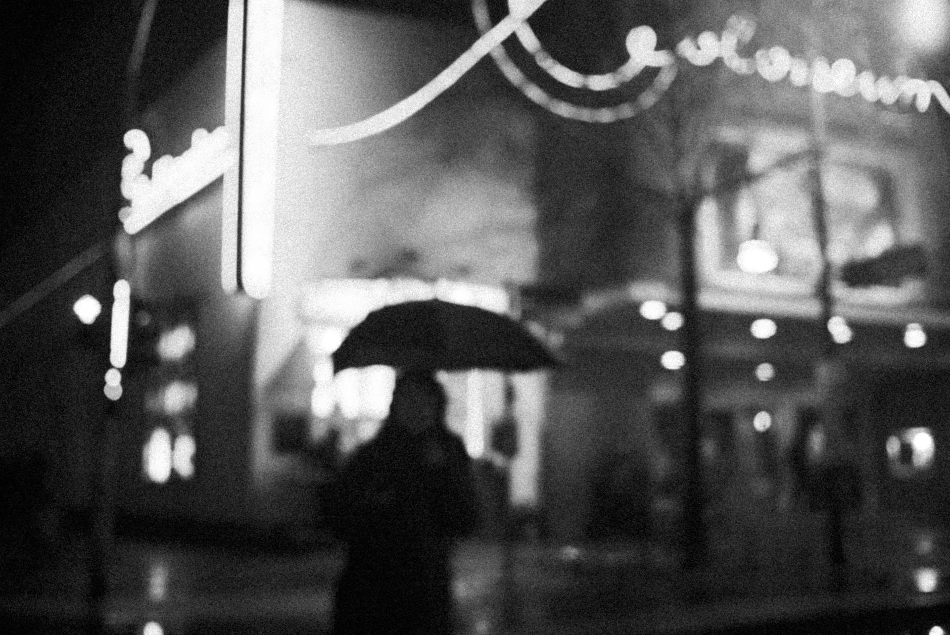 夜晚霓虹燈下，撐傘的人在雨中城市行走 — 黑暗悲傷動圖 壁紙