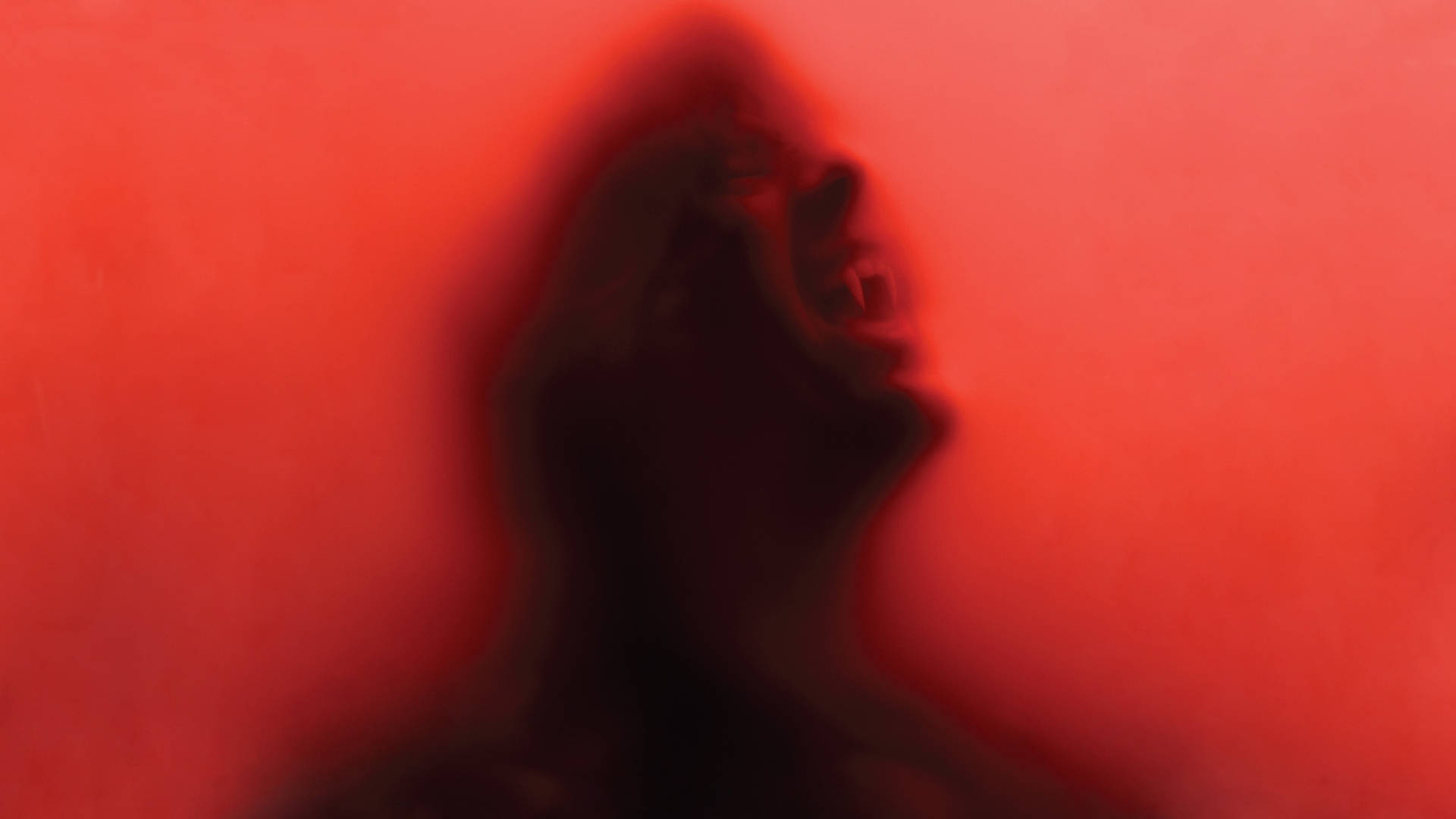 True Blood 桌布 壁紙 — 一個模糊的尖叫人頭剪影，背景是鮮紅色。