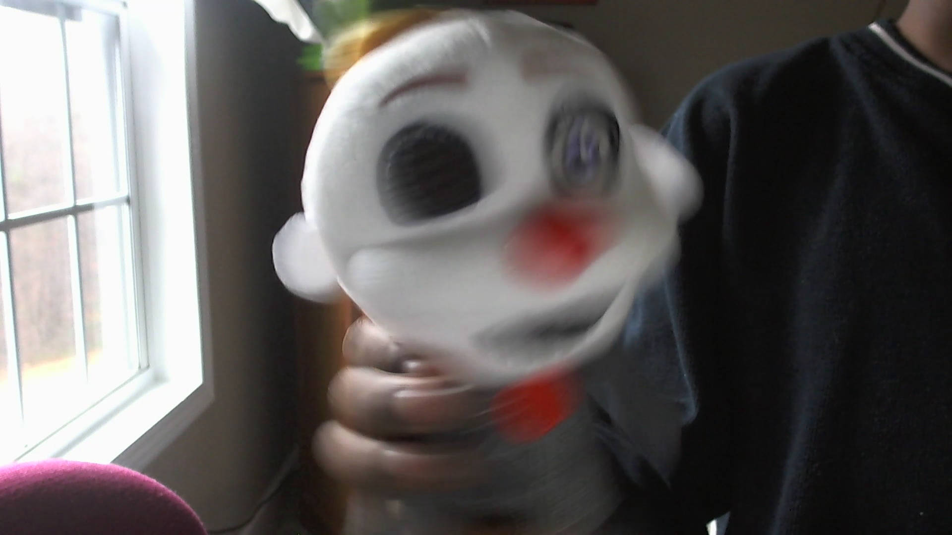 Ennard 桌布 壁紙 — 一個模糊的特寫，一個人在室內靠近窗戶的地方拿著一個白色小丑面具，有紅色鼻子和大眼睛。