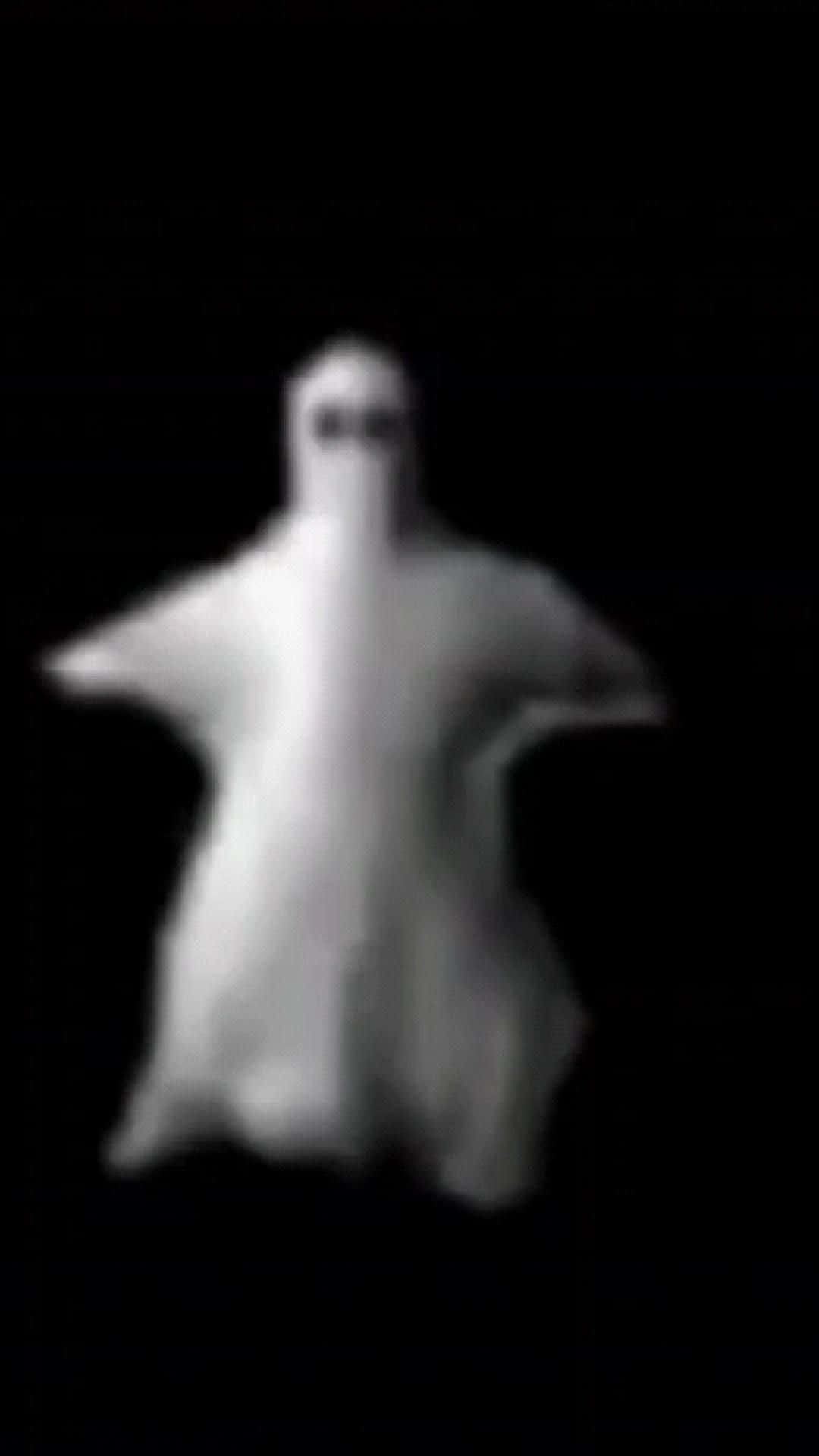 一個模糊的鬼魂，眼睛發光，漂浮在黑暗中。 — 鬼魂 GIF 壁紙