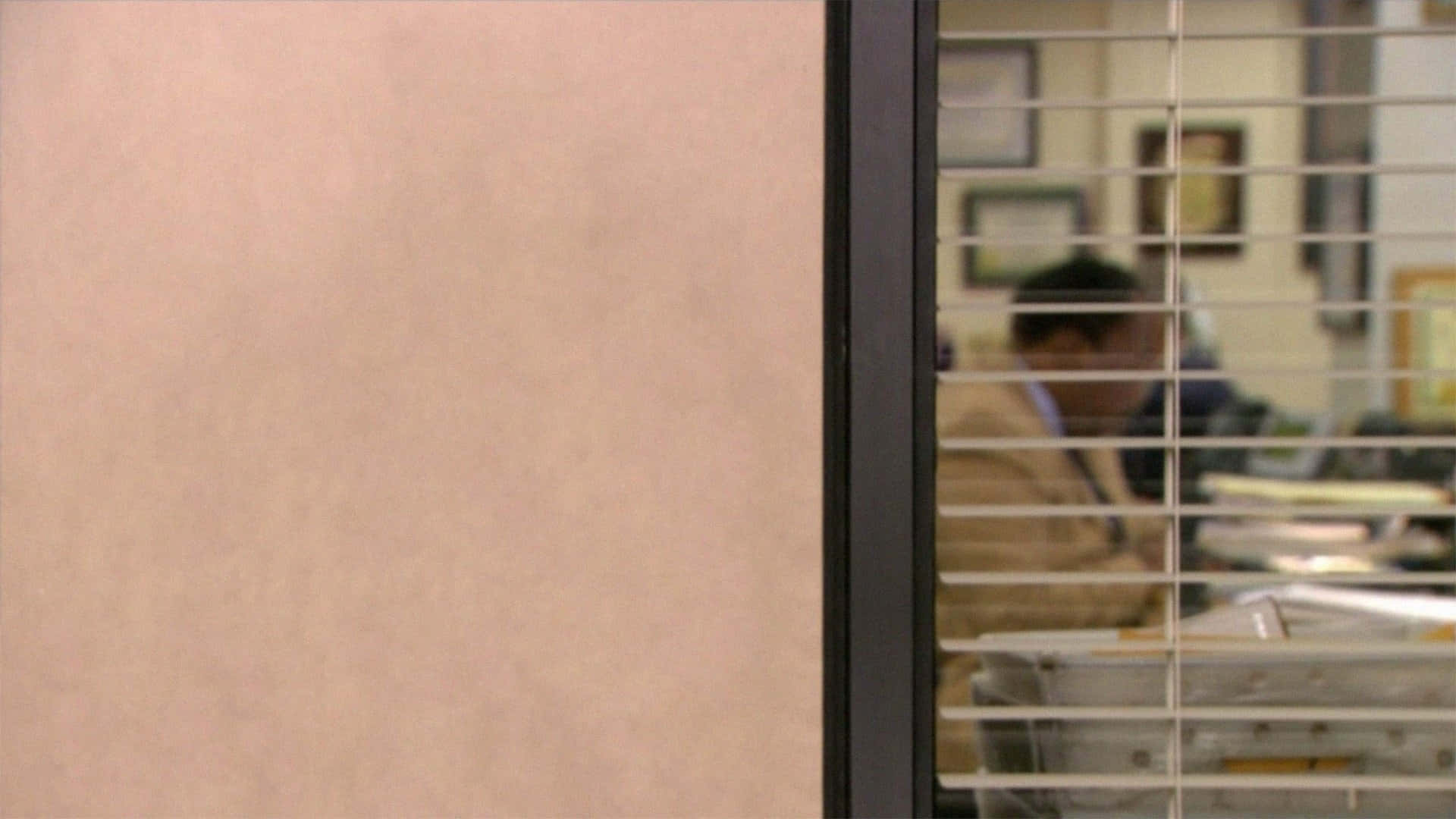 The Office 桌布 壁紙 — 一個模糊的辦公室職員坐在百葉窗後的隔間裡，透過米色隔板牆看到。