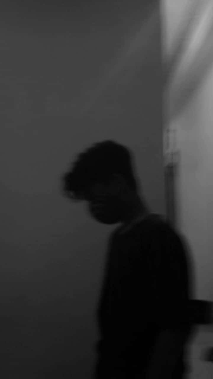 reflection 桌布 壁紙 — 一個模糊的黑白剪影，一個人走過牆邊，光線從側面射入。