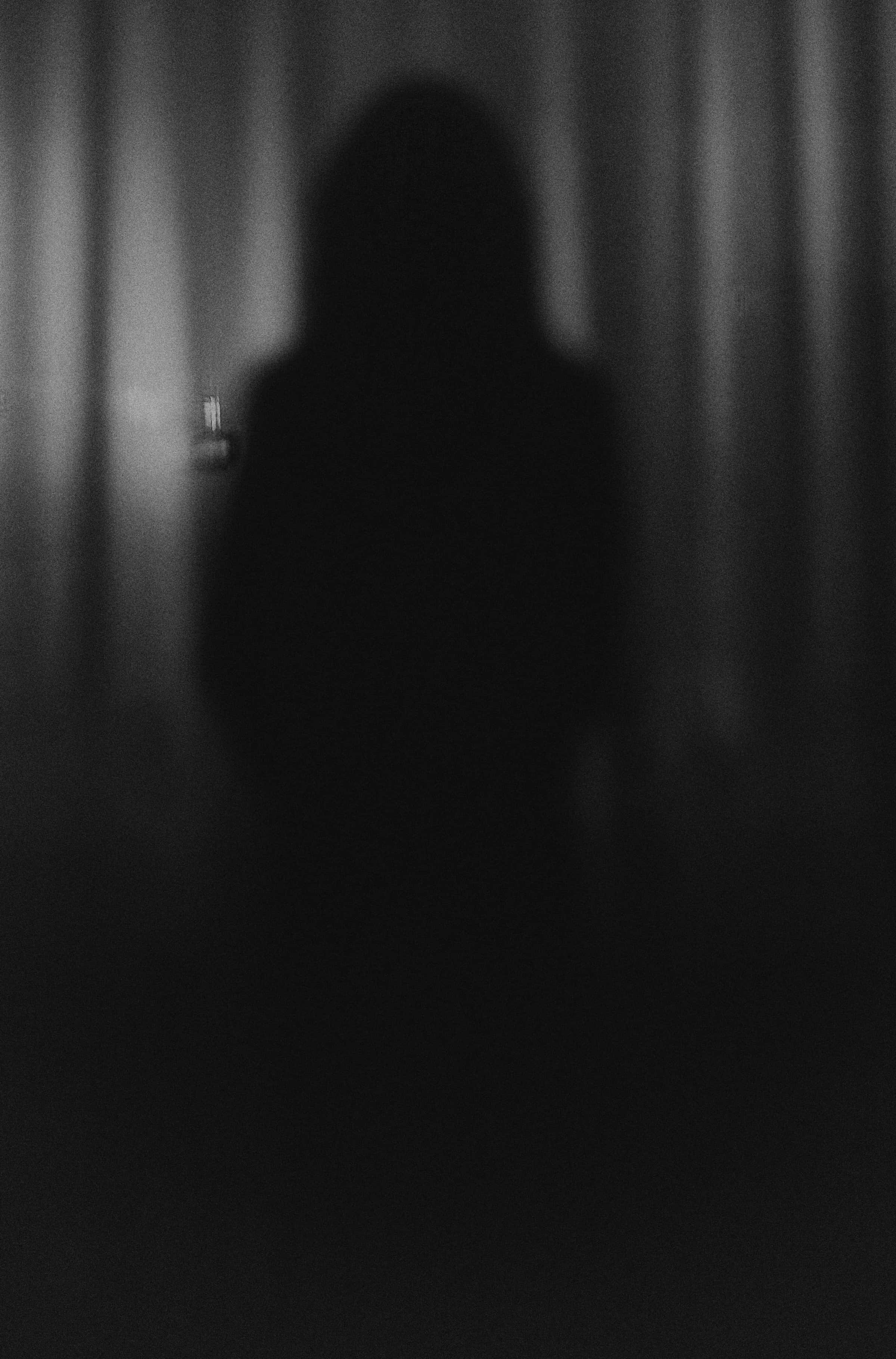 shadow 桌布 壁紙 — 一個模糊的黑色人影站在昏暗的窗簾前，營造出一種詭異而神秘的氛圍。