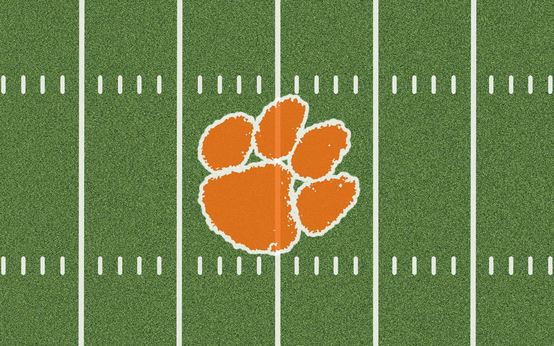 tigers 桌布 壁紙 — 一個橙色老虎爪標誌，位於帶有白色碼線的綠色足球場中央。