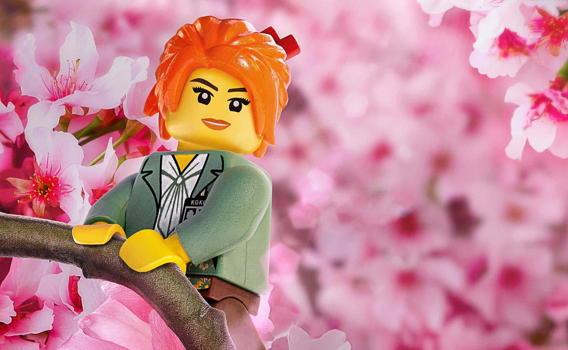 樂高 桌布 壁紙 — 一個橙色頭髮的LEGO迷你人偶棲息在柔和的粉紅色櫻花中的樹枝上。