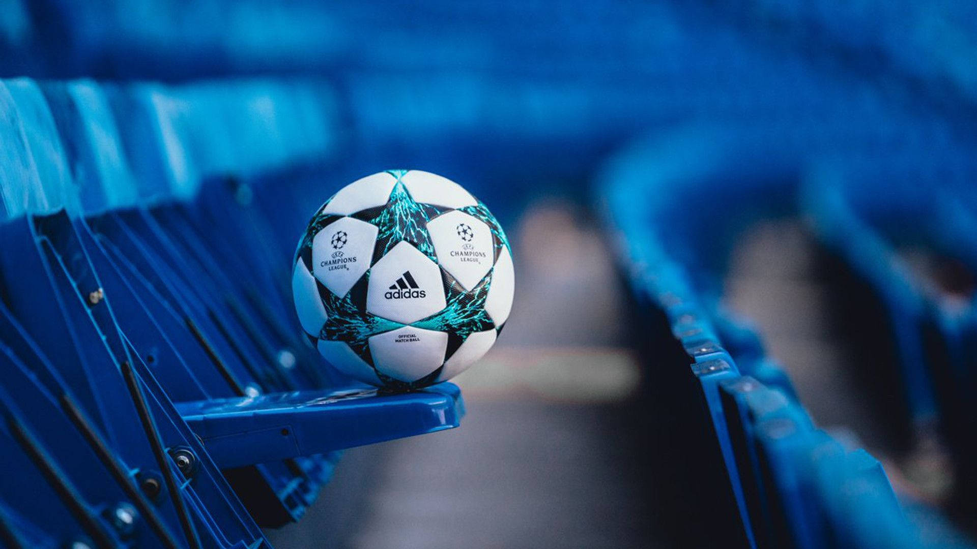 Champions League 桌布 壁紙 — 一個歐冠足球放在藍色球場座位上，背後有模糊的座位排。