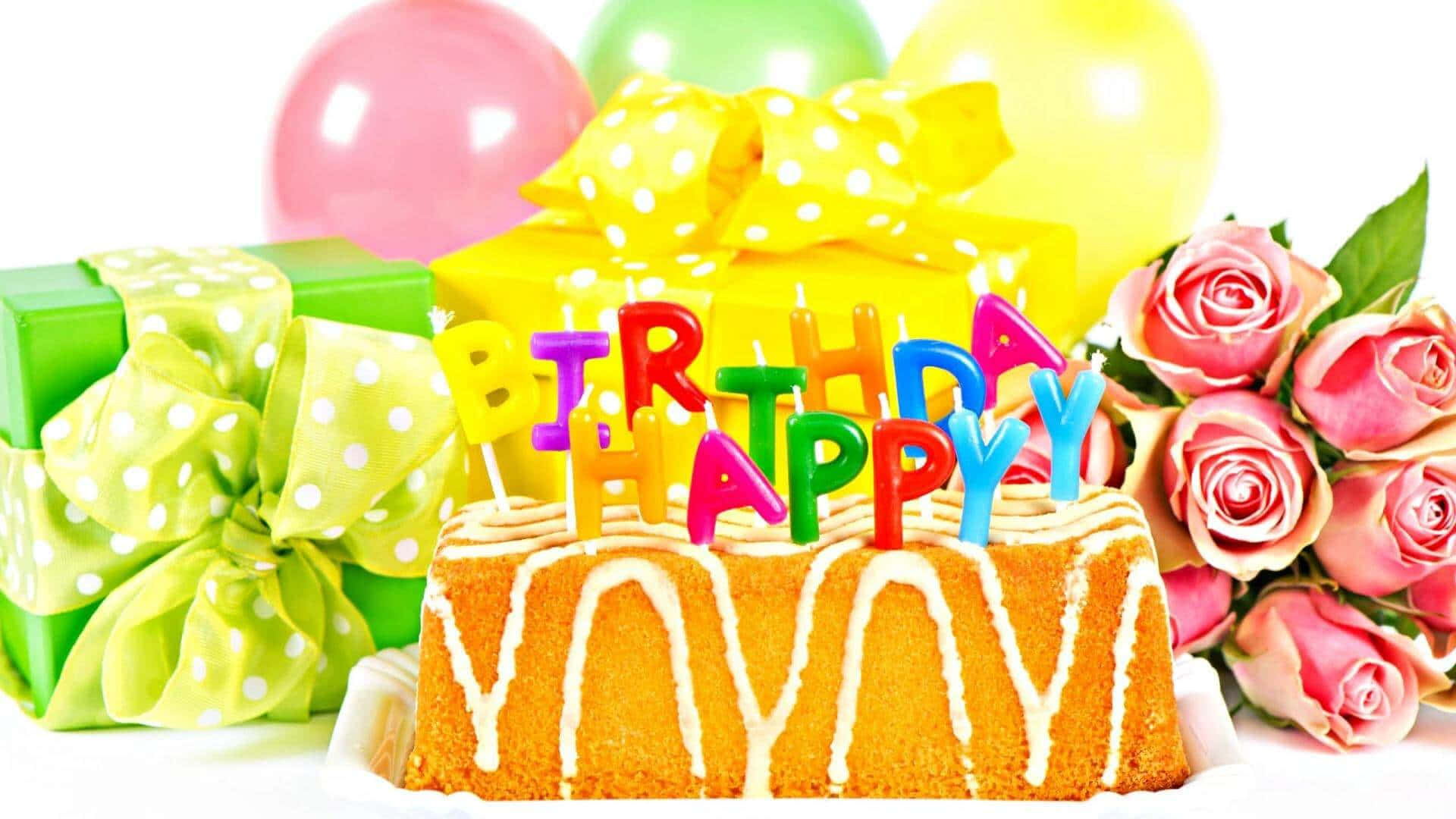 生日快樂 桌布 壁紙 — 一個歡樂的生日蛋糕，上面有彩色字母蠟燭，旁邊放著包裝好的禮物和粉紅玫瑰，背景是白色。