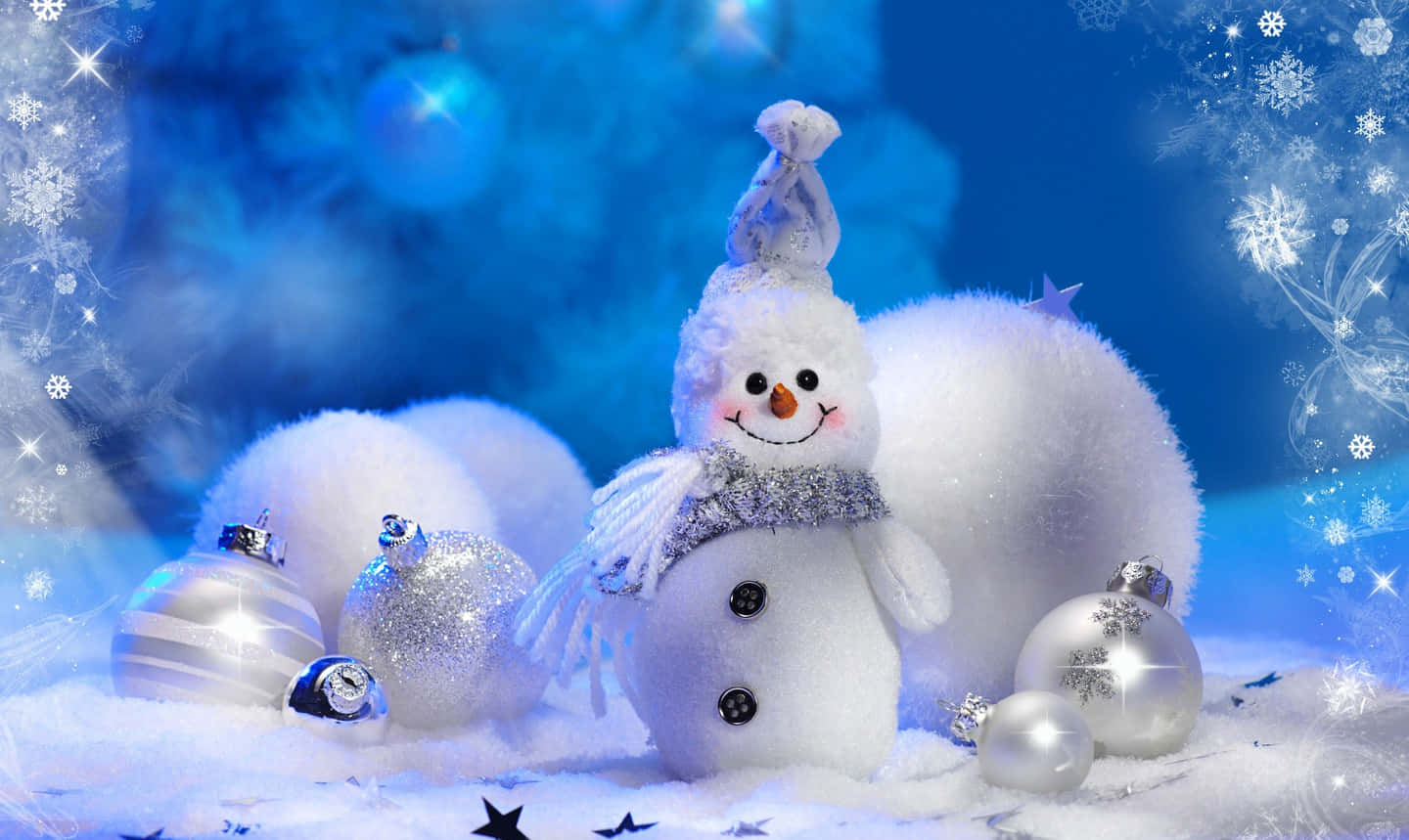 雪人 桌布 壁紙 — 一個毛茸茸的雪人，戴著圍巾和帽子，站在雪地上，旁邊是閃閃發光的銀色裝飾品，背景是藍色的冬日天空。