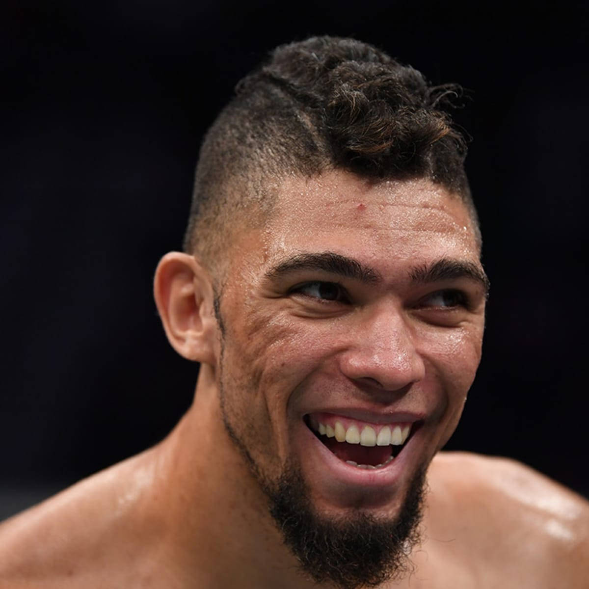 Smile 桌布 壁紙 — 一個汗流浹背、留鬍子、頭髮有型的戰士，在深色背景下開懷大笑。