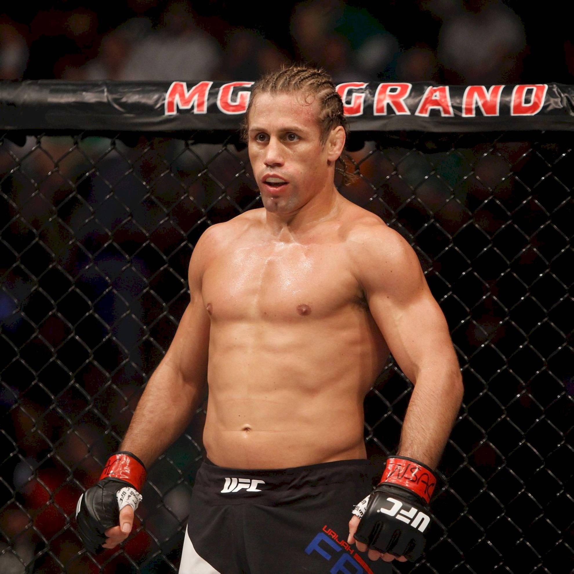 UFC 桌布 壁紙 — 一個汗流浹背的UFC拳手站在八角籠內，圍欄上方可見「MGM GRAND」字樣。