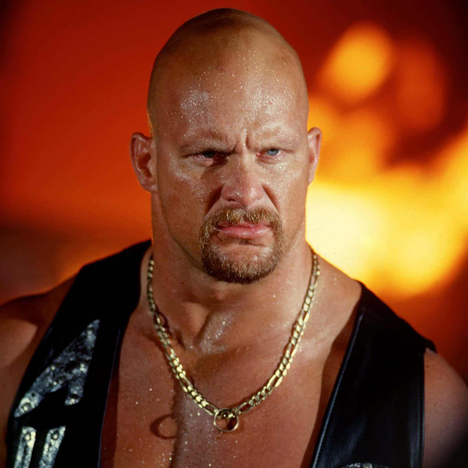 WWE 桌布 壁紙 — 一個汗流浹背的光頭摔角手，留著山羊鬍，在熾熱的橙色背景下凝視著。