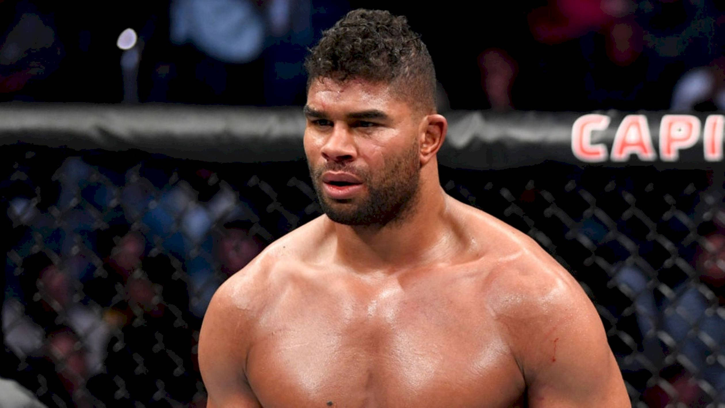 UFC 桌布 壁紙 — 一個汗流浹背的肌肉發達鬥士在八角籠內，專注地進行綜合格鬥比賽。