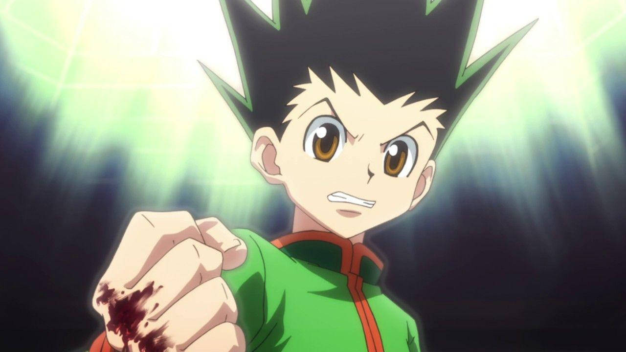 獵人 x 獵人 桌布 壁紙 — 一個決心堅定的動漫男孩，有著刺蝟般的黑髮和綠色外套，在發光的綠色背景下握緊血淋淋的拳頭。