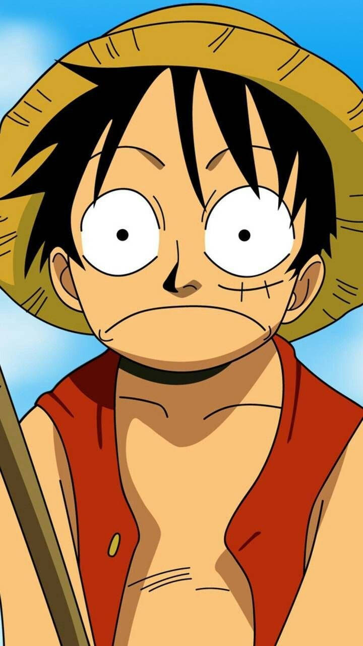 Luffy Funny 桌布 壁紙 — 一個決心堅定的動畫男孩，黑髮戴草帽，在明亮的藍天下凝視著。