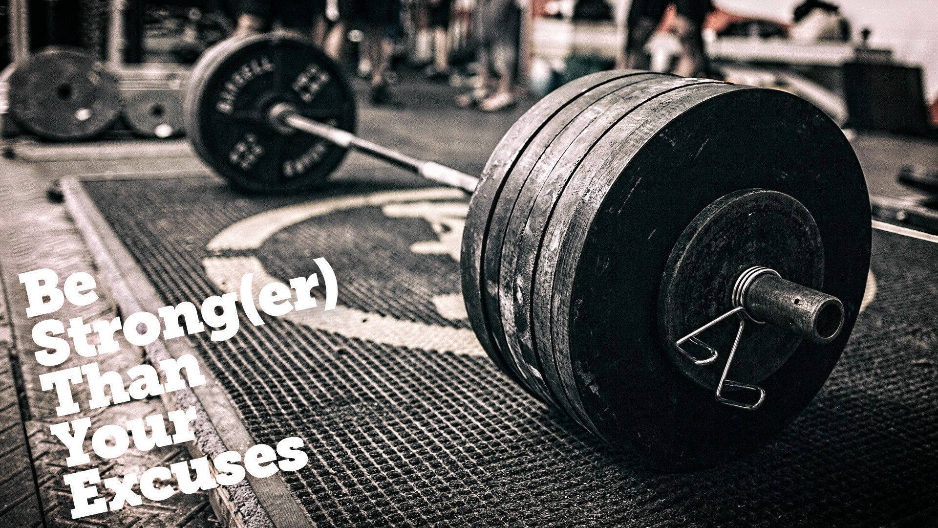 Motivation 桌布 壁紙 — 一個沉重的槓鈴放在健身房地板上，圖片上覆蓋著勵志文字。