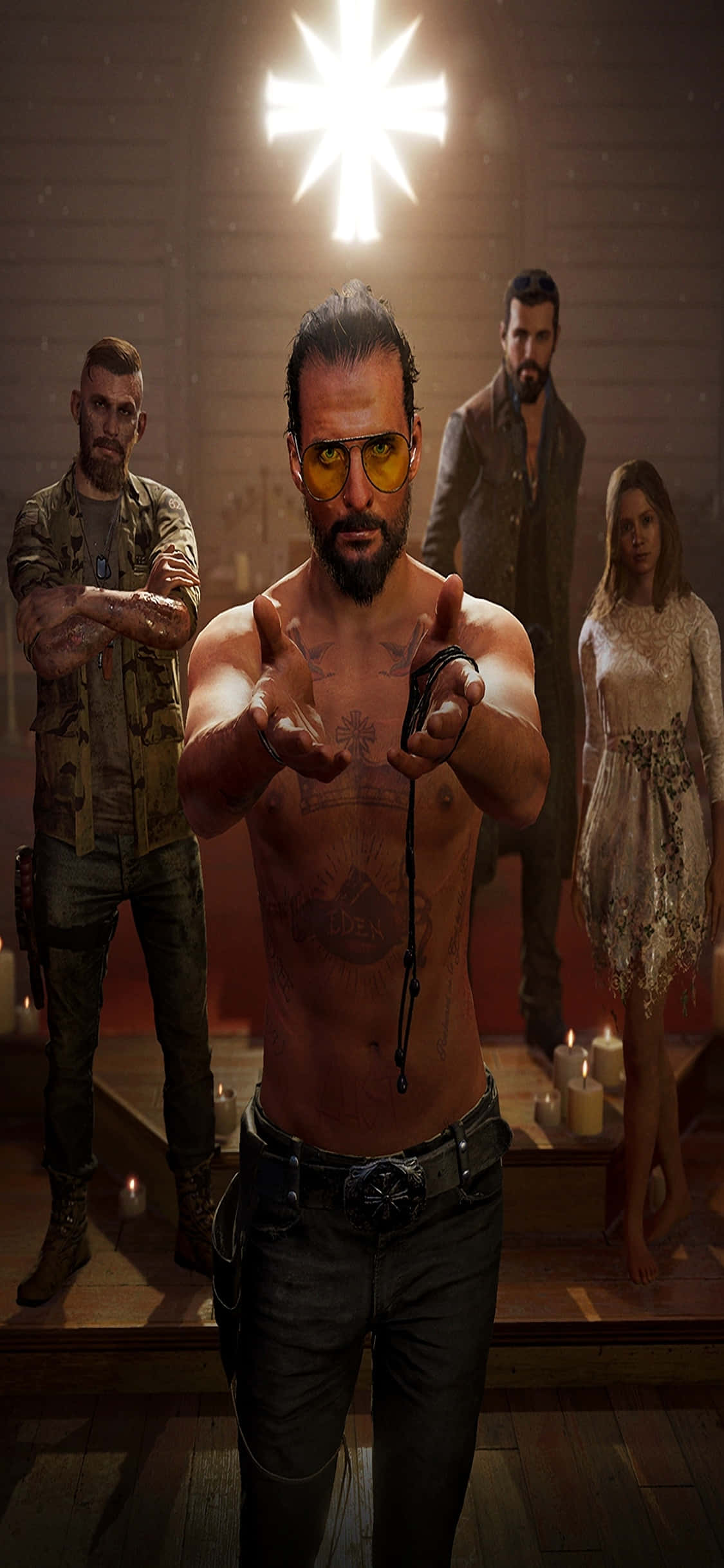 iPhone Xs Far Cry 5 桌布 壁紙 — 一個沒穿上衣、有刺青且戴黃色眼鏡的男人，在一個光線昏暗、有蠟燭和發光十字架在他上方的房間裡，指向前面。