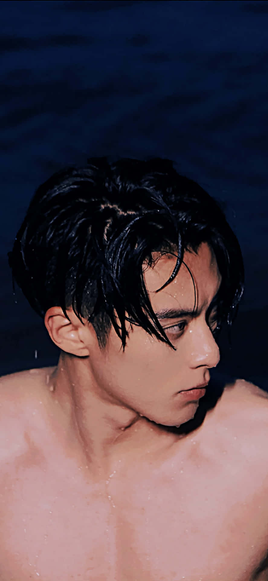 Dylan Wang 桌布 壁紙 — 一個沒穿上衣的男人，濕透的深色頭髮，在深藍色水背景前向下凝視。