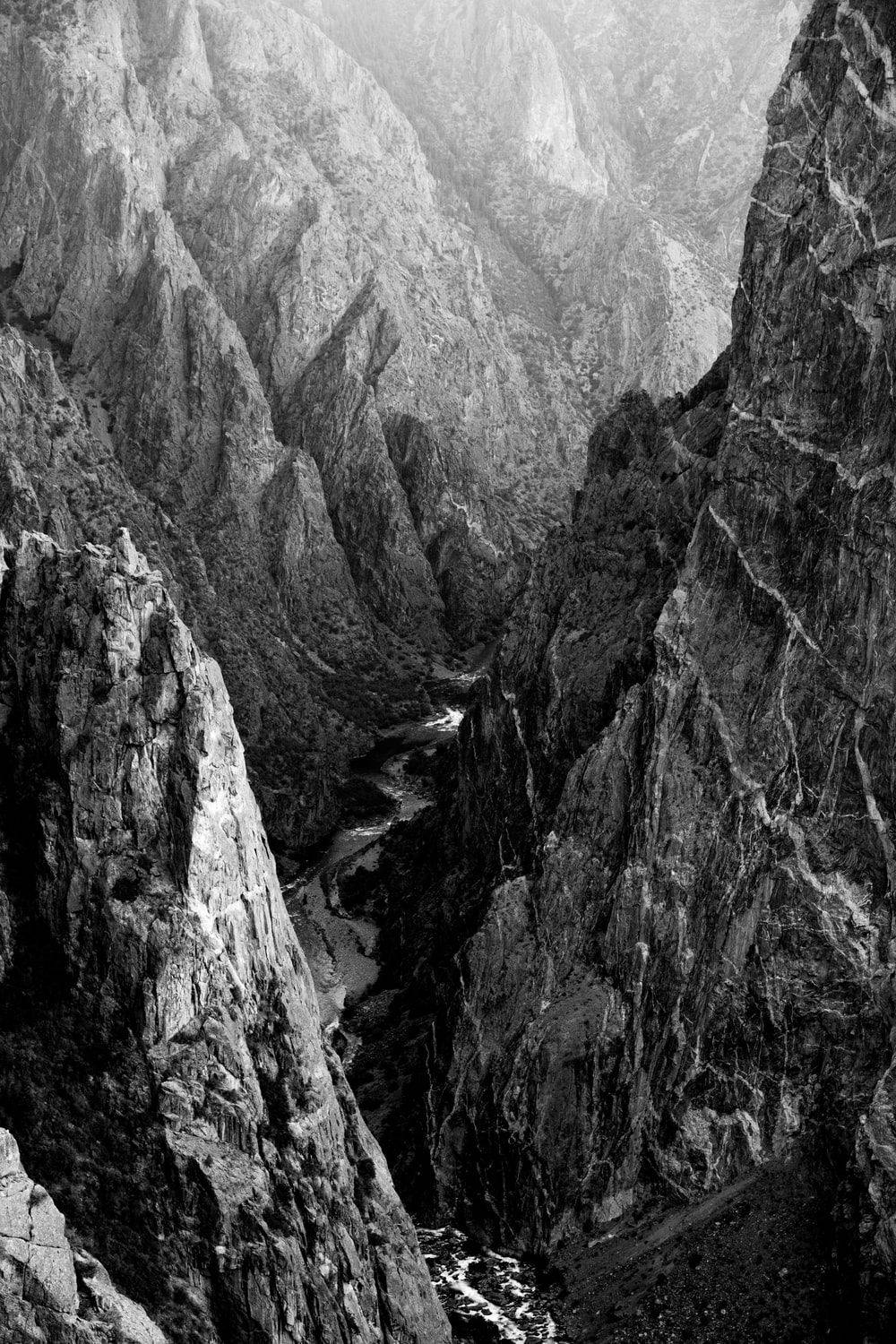 Topography 桌布 壁紙 — 一個深峽谷的戲劇性黑白景觀，蜿蜒的河流穿過高聳崎嶇的懸崖。