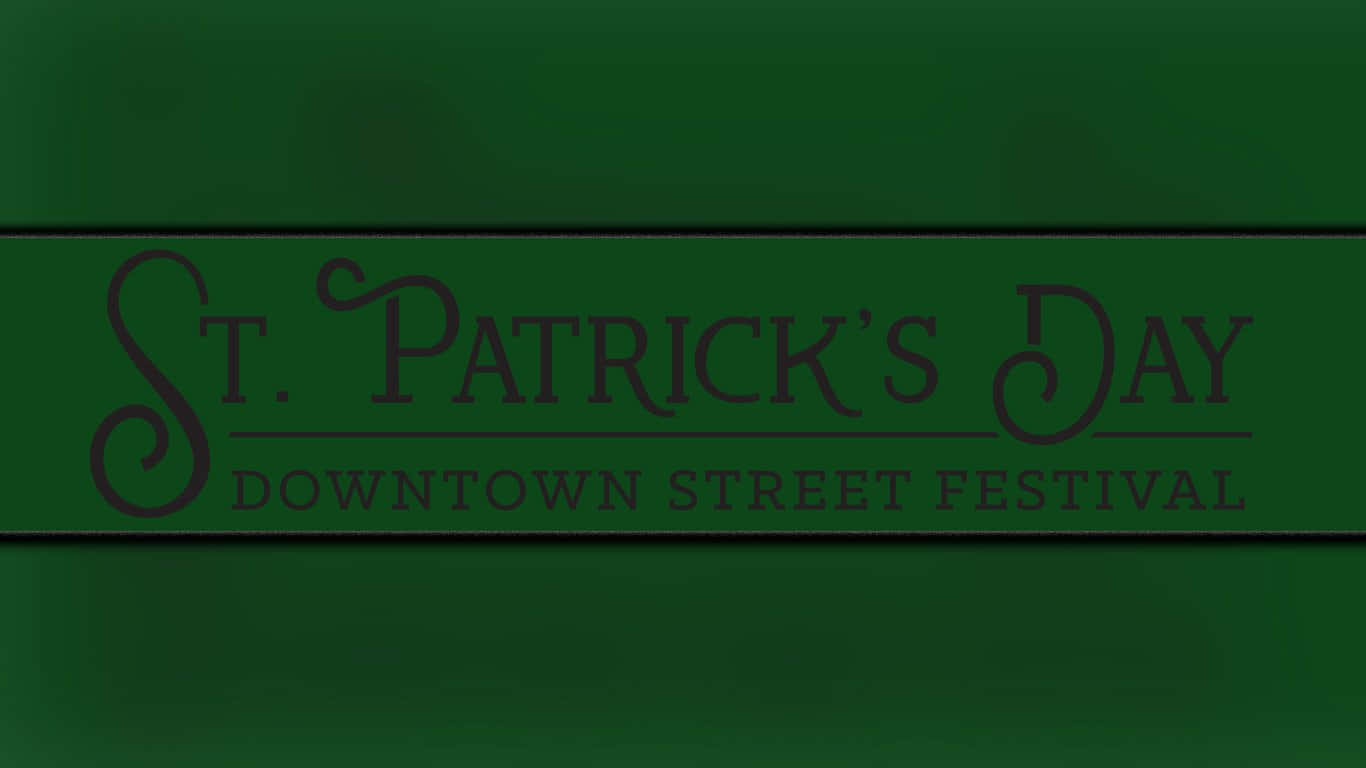 St Patrick's Day 桌布 壁紙 — 一個深綠色橫幅，上面有優雅的字體寫著 St. Patrick's Day Downtown Street Festival，背景有紋理。