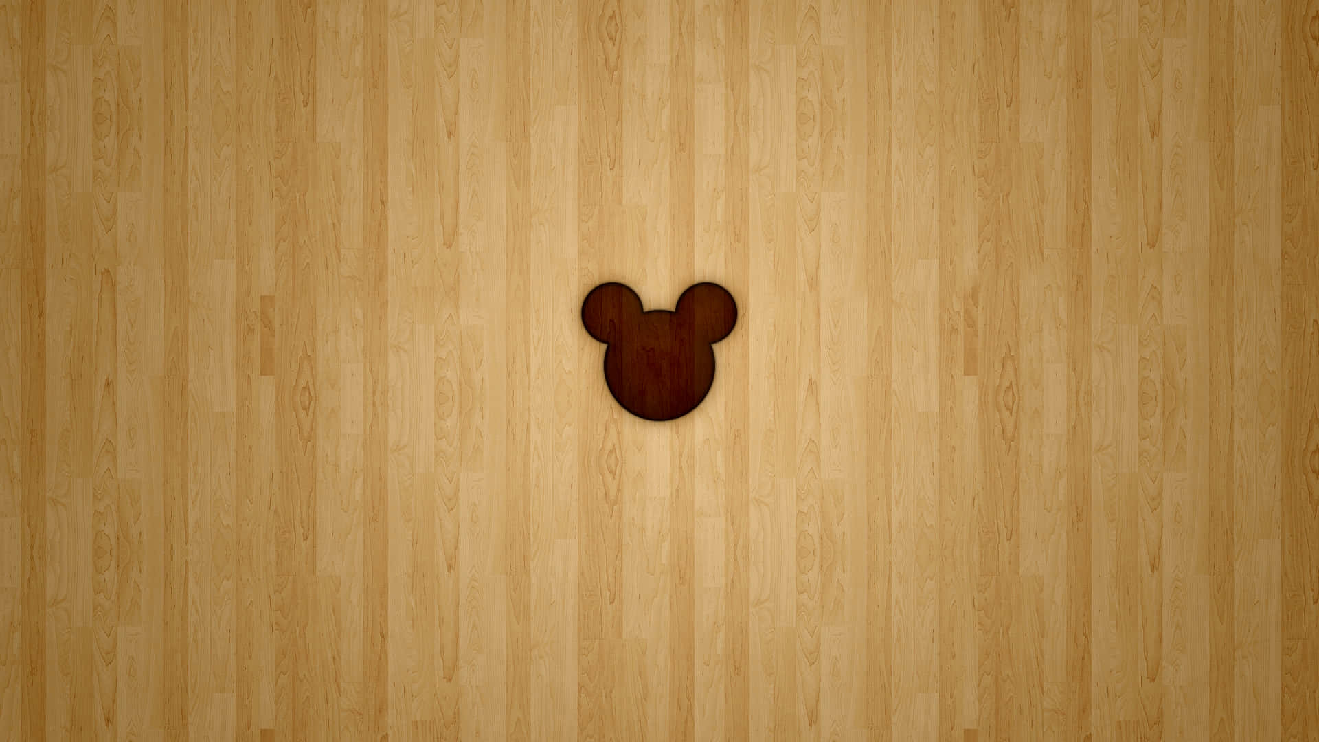 Mickey Mouse Desktop 桌布 壁紙 — 一個深色木製米奇老鼠頭剪影，置於淺色木地板中央，地板帶有垂直紋理。