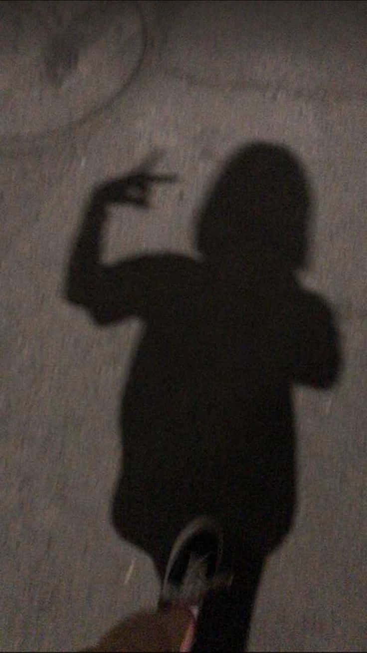桌布 壁紙 — 一個深色的人影在紋理牆壁上做出舉起一隻手臂的手勢。