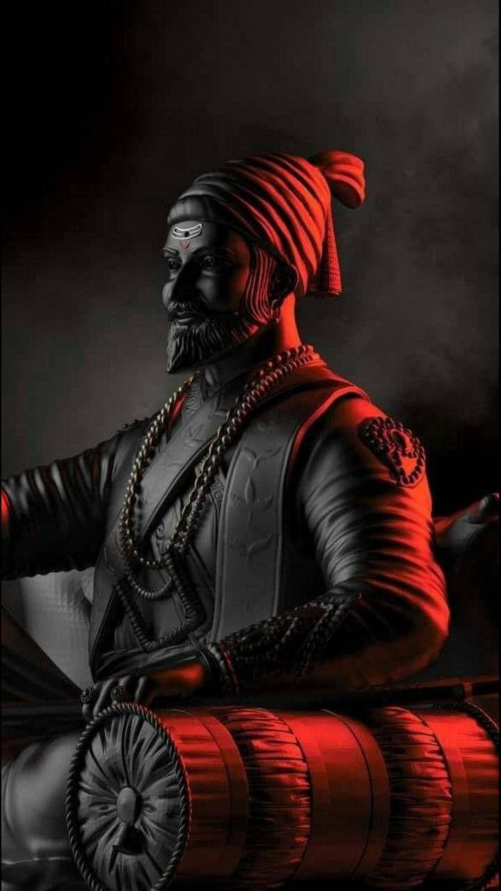 Chhatrapati Shivaji Maharaj 桌布 壁紙 — 一個深色皮膚的戰士，戴著紅色頭巾和盔甲，在戲劇性的紅光下，對著煙霧繚繞的黑色背景，手持一面鼓。