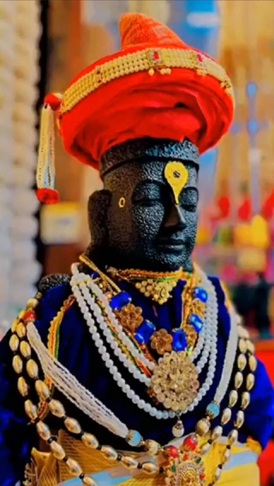 Statue Aesthetic 桌布 壁紙 — 一個深色皮膚神像的特寫，飾有鮮豔的紅色頭巾和精緻的金色和藍色珠寶。
