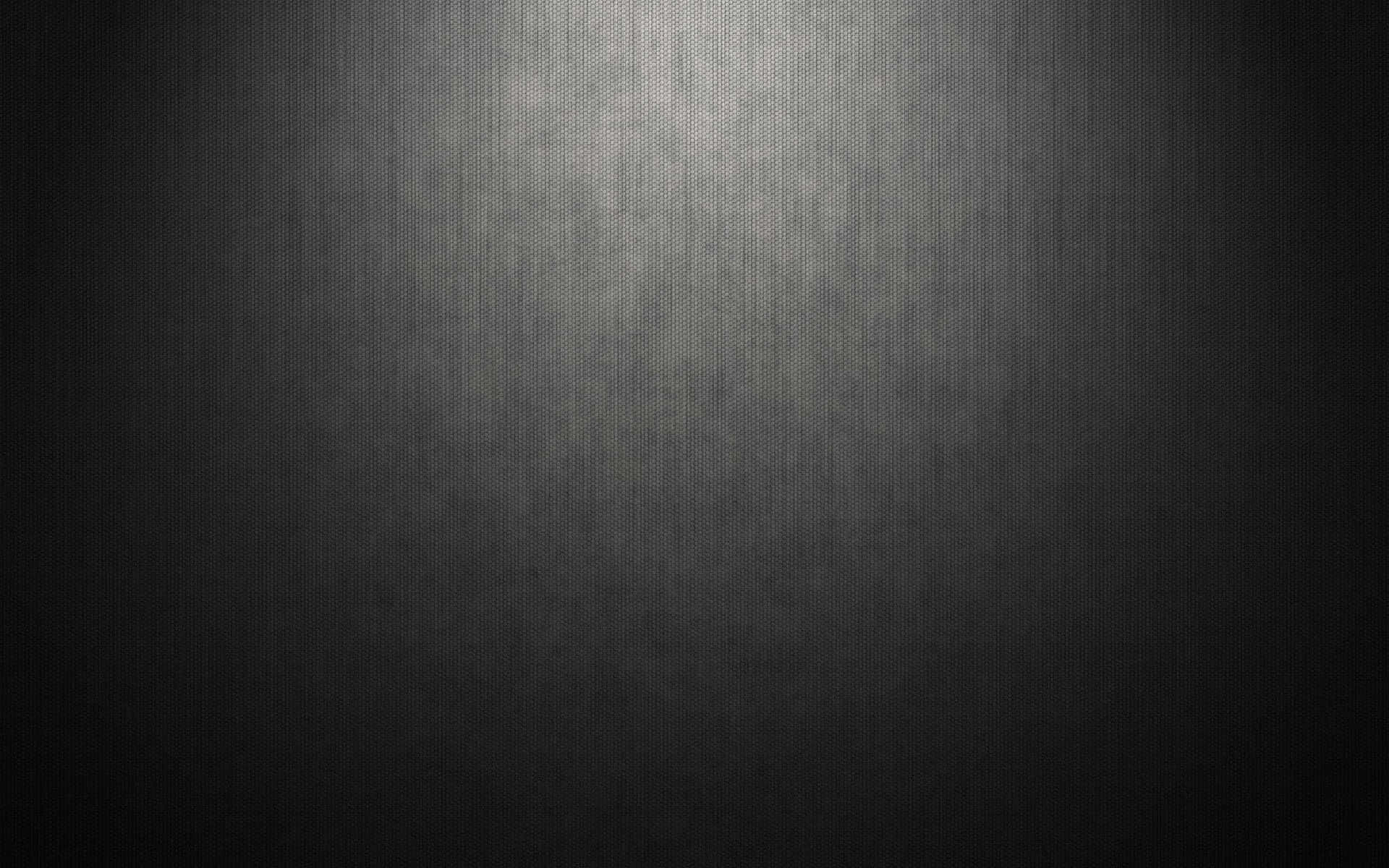 Cool Grey 桌布 壁紙 — 一個深色紋理表面，被柔和聚光燈照亮，形成從明亮中心到深邃陰影的漸變。