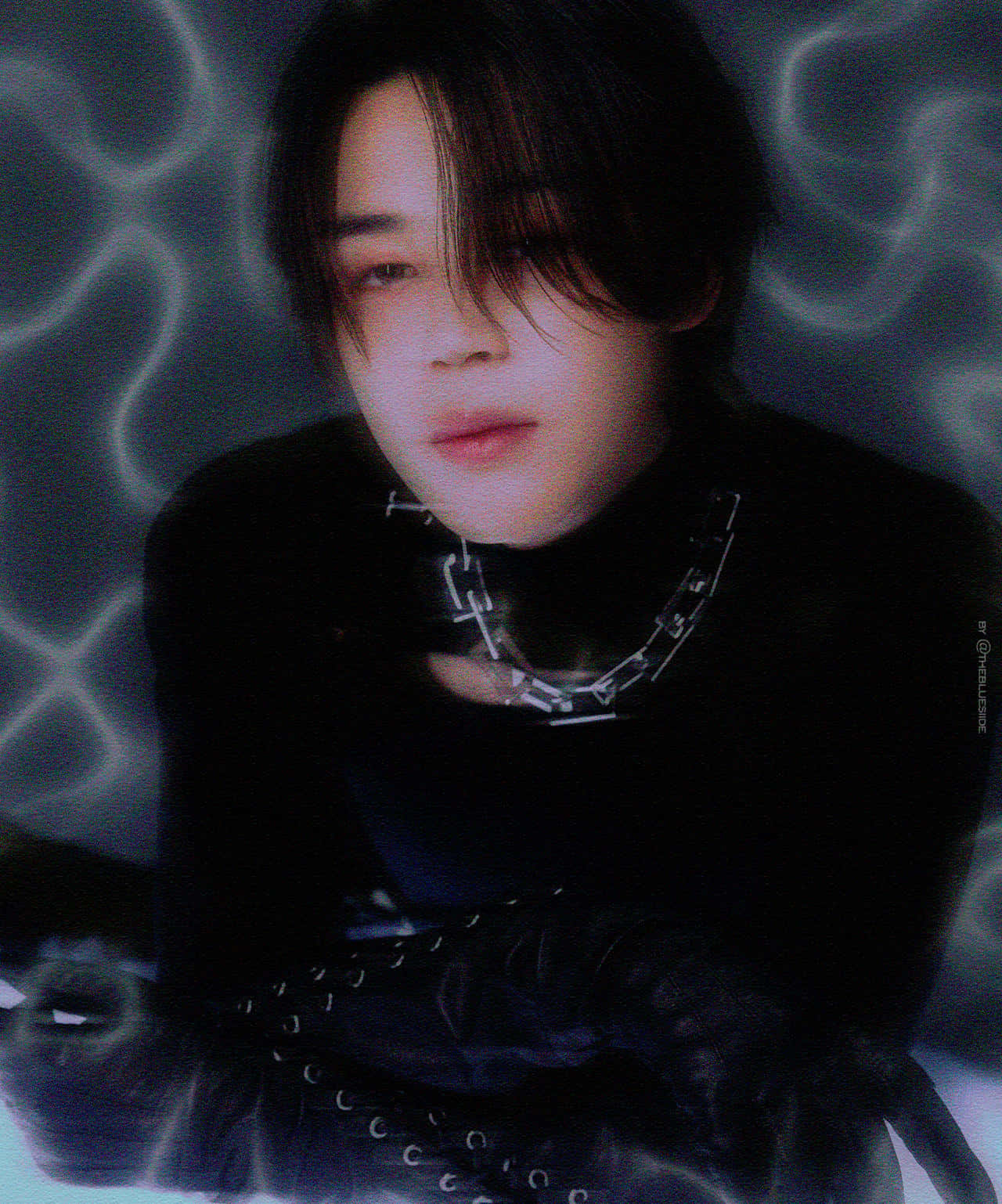 Jimin Aesthetic 桌布 壁紙 — 一個深色頭髮、戴著鏈條項鍊的人，在發光的藍色抽象背景前溫柔地凝視。