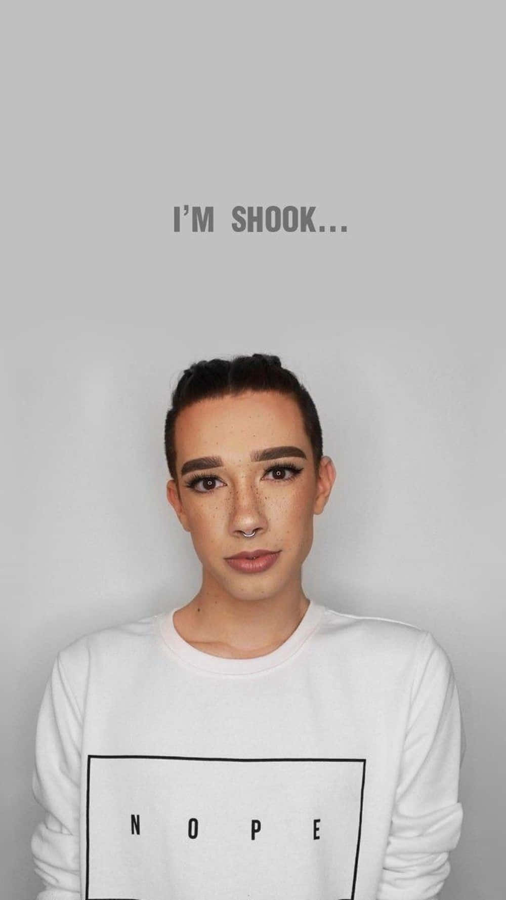 make up 桌布 壁紙 — 一個深色頭髮、戴鼻環的人，穿著印有 'NOPE' 字樣的白色運動衫，嚴肅地盯著鏡頭。