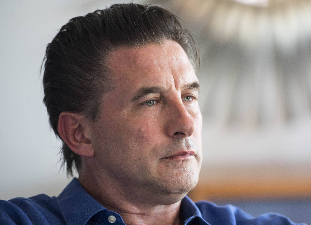 William Baldwin 桌布 壁紙 — 一個深色頭髮、藍色眼睛的男人在柔和光線的室內環境中若有所思地望向別處的特寫肖像。