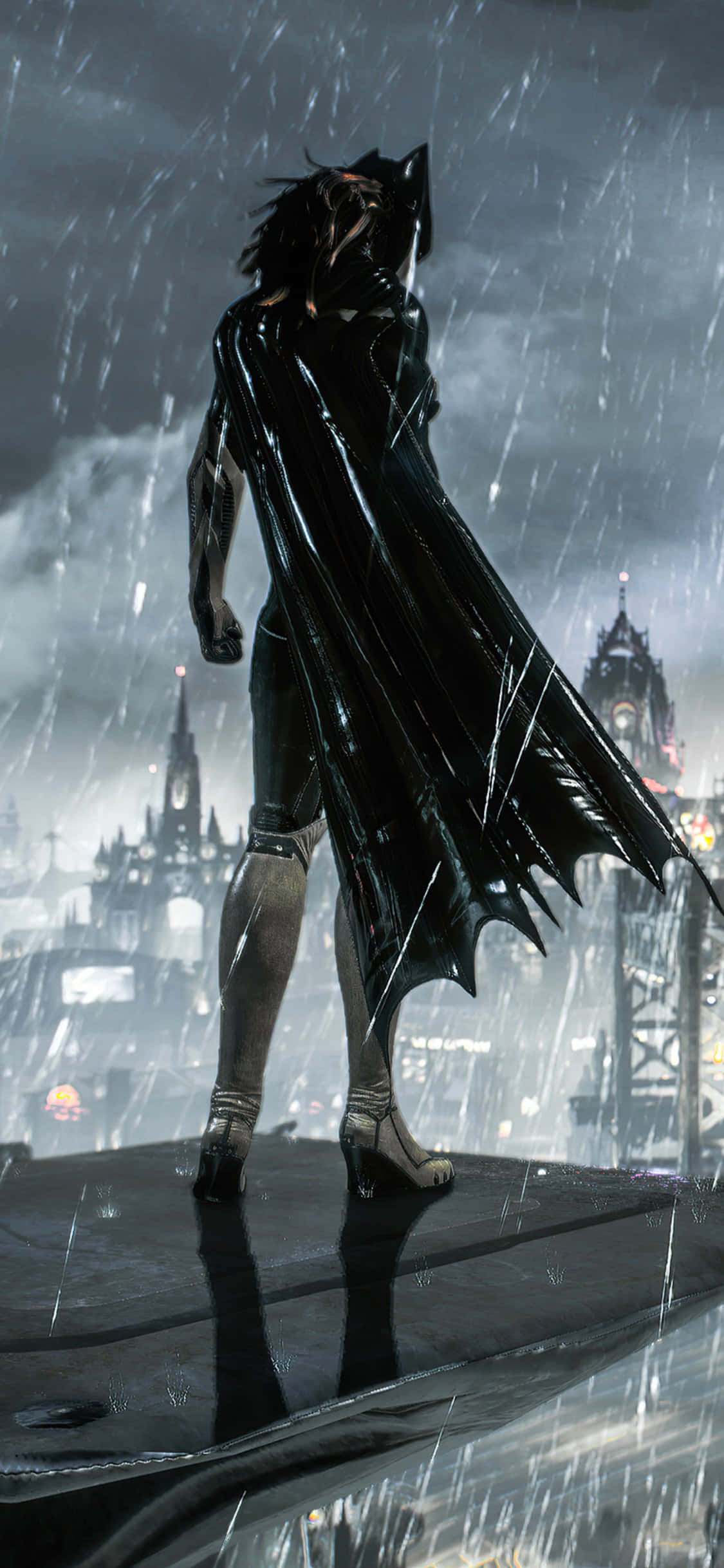 Batman Arkham Knight 桌布 壁紙 — 一個深色頭髮、身穿亮黑色斗篷的人物獨自站在濕漉漉的屋頂上，夜晚的哥德式城市景觀中下著雨。