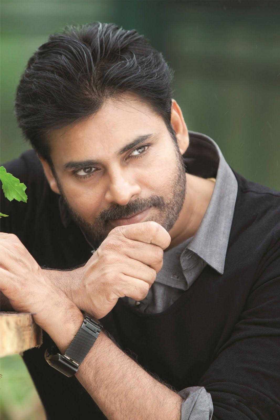 Pawan Kalyan 桌布 壁紙 — 一個深色頭髮和鬍鬚的男人，在模糊的綠色背景上用手托著下巴。