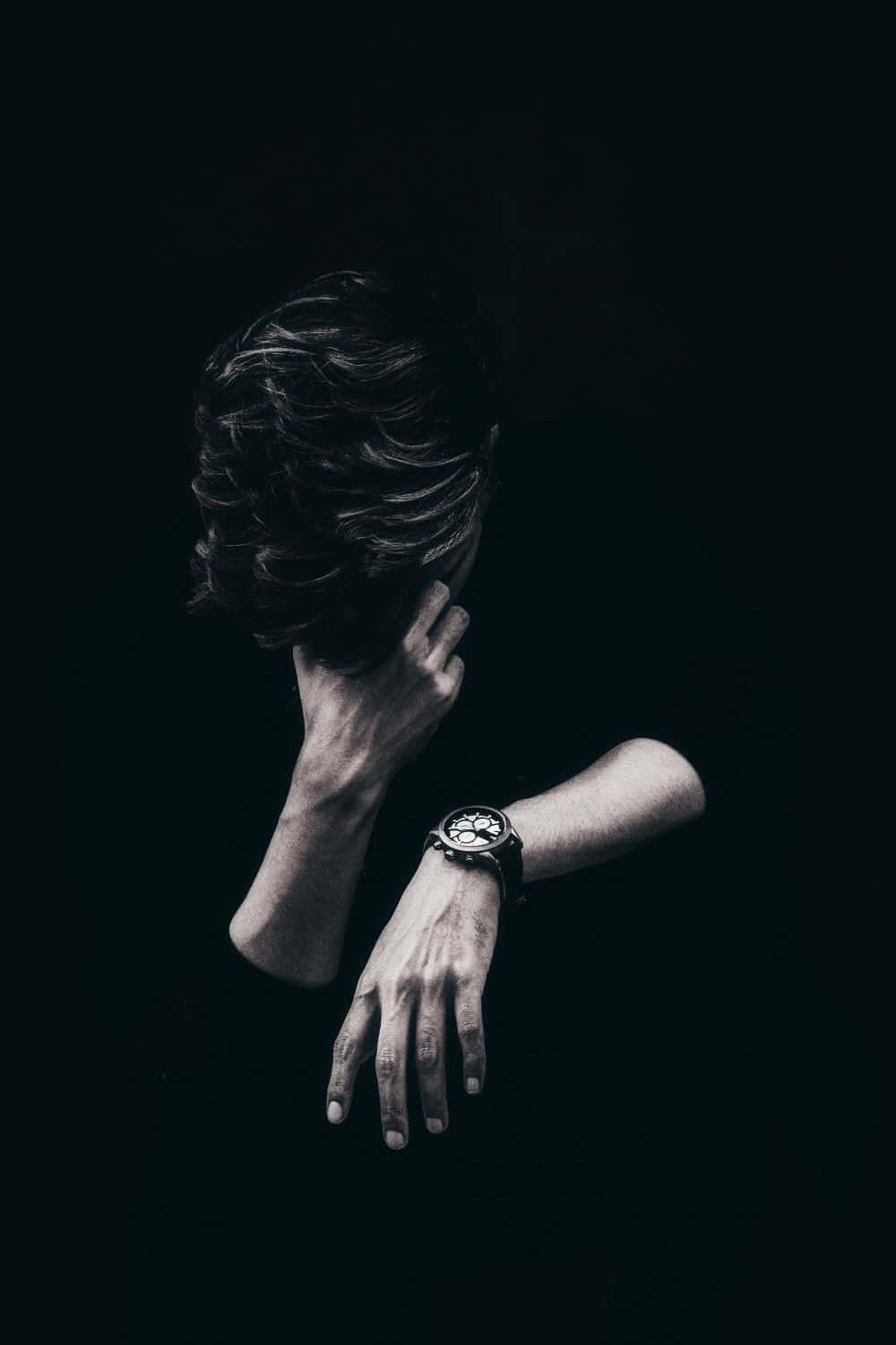 Alone 桌布 壁紙 — 一個深色頭髮的人背對鏡頭，手靠近臉部，戴著手錶，背景為黑色。