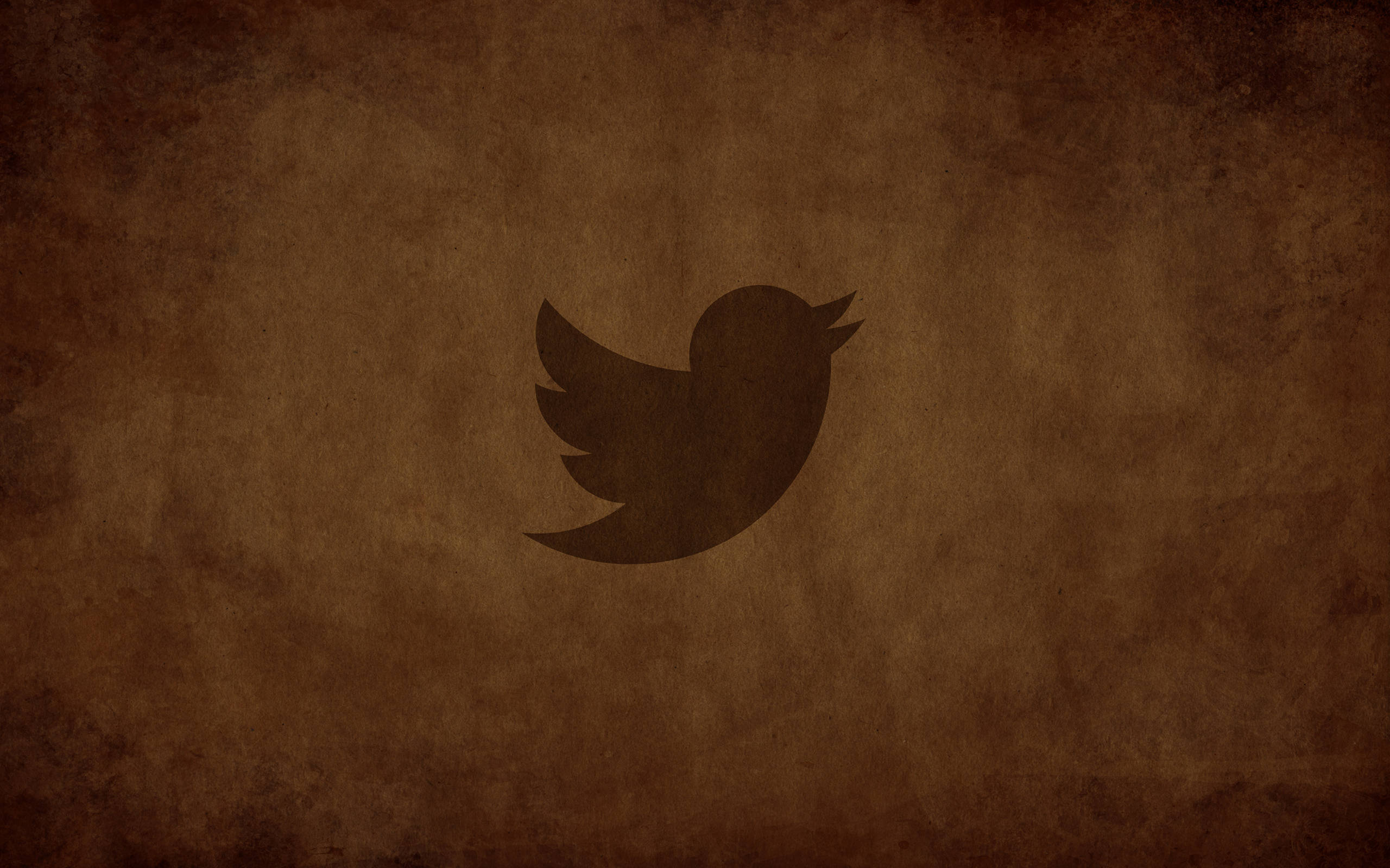 Twitter 桌布 壁紙 — 一個深色鳥標誌居中在帶紋理的棕色復古紙背景上。