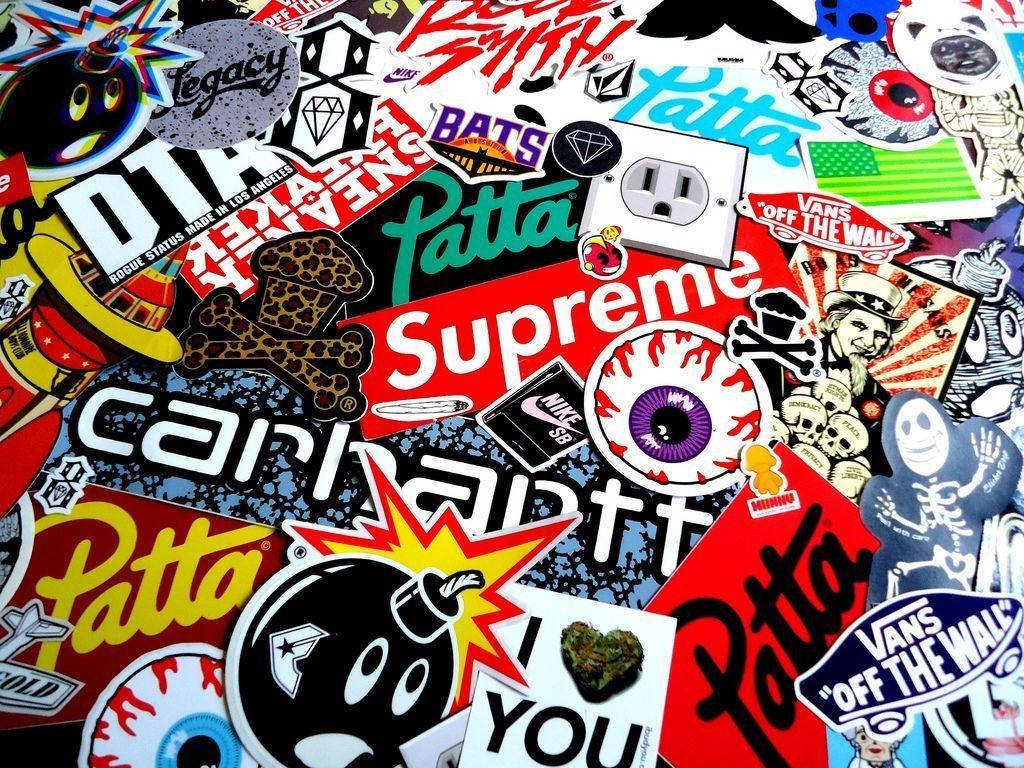 超屌 Supreme 桌布 壁紙 — 一個混亂的拼貼畫，色彩繽紛的街頭服飾品牌貼紙（如 Supreme 和 Vans）覆蓋表面。