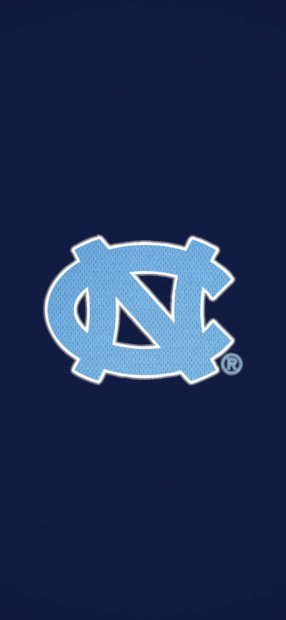 Tar Heels 桌布 壁紙 — 一個淺藍色刺繡的NC標誌，帶有白色縫線，居中於純海軍藍背景上。
