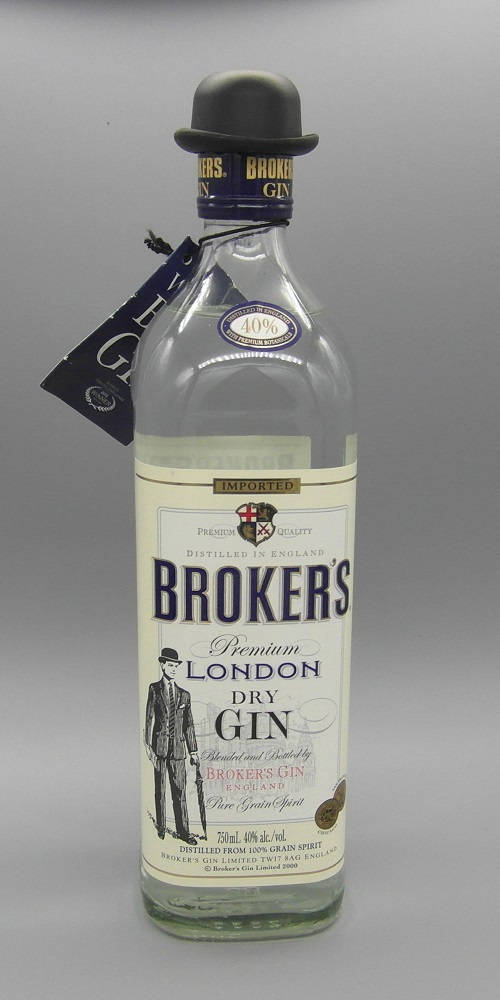 bottle 桌布 壁紙 — 一個清晰的玻璃瓶裝有 Broker's Premium London Dry Gin，帶有圓頂禮帽塞子和復古標籤，背景為中性灰色。