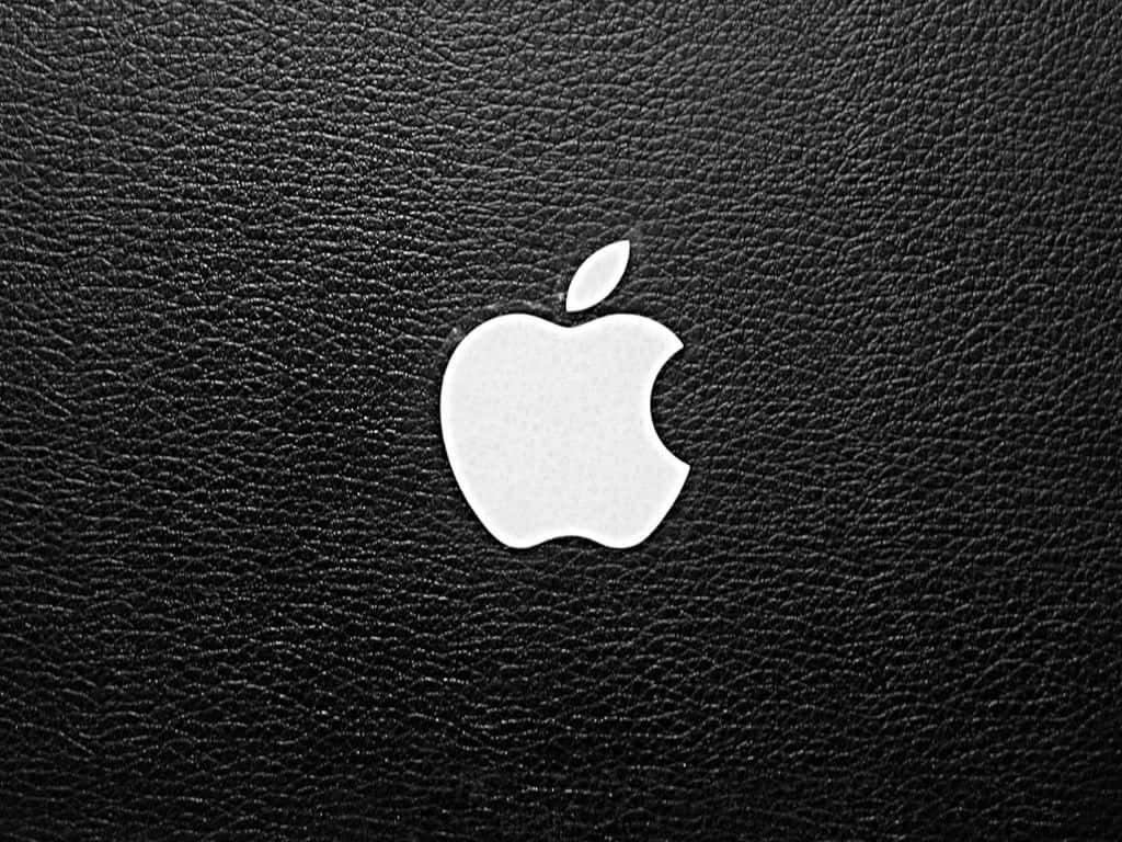 Apple 4K 桌布 壁紙 — 一個清晰的白色Apple標誌，置於帶有細膩縫線細節的紋理黑色皮革中央。