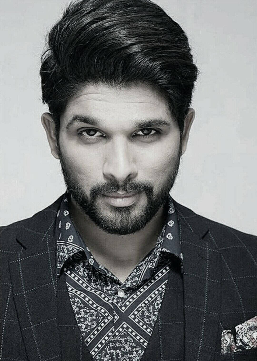 Allu Arjun 桌布 壁紙 — 一個清晰的黑白肖像，展示一位留著時尚髮型和鬍鬚的男子，身穿格紋西裝外套內搭圖案襯衫。