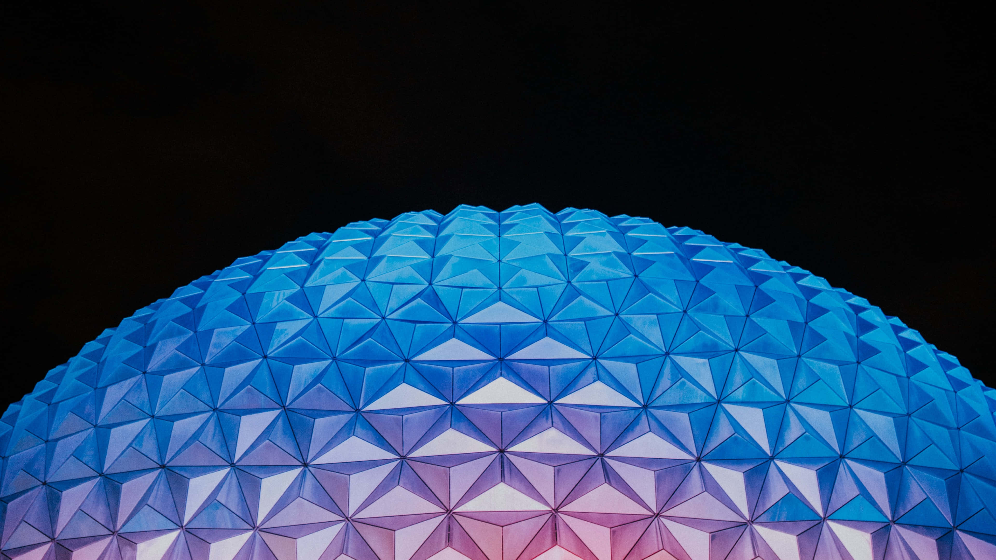 Disney World Desktop 桌布 壁紙 — 一個測地線穹頂的特寫，在黑暗的夜空中發出藍色和紫色的光芒。
