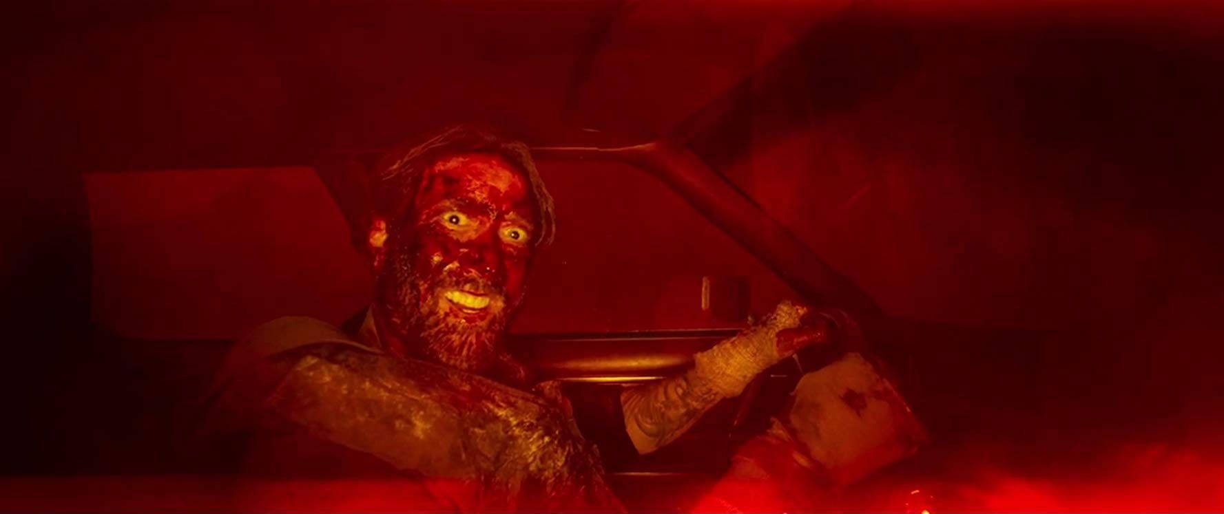 Nicolas Cage 桌布 壁紙 — 一個渾身是血、眼睛發光的殭屍抓住方向盤，車內籠罩著不祥的紅光。