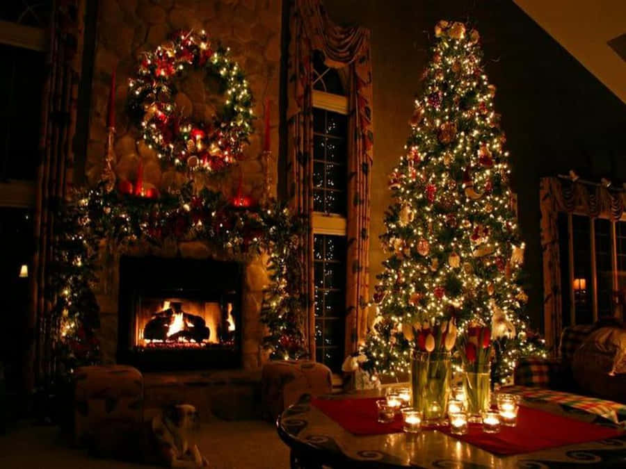 Aesthetic Christmas Tree 桌布 壁紙 — 一個溫暖照明的客廳，設有一個裝飾著節日花環的發光壁爐，旁邊有一棵高大的裝飾聖誕樹，旁邊是一張點著蠟燭的餐桌。