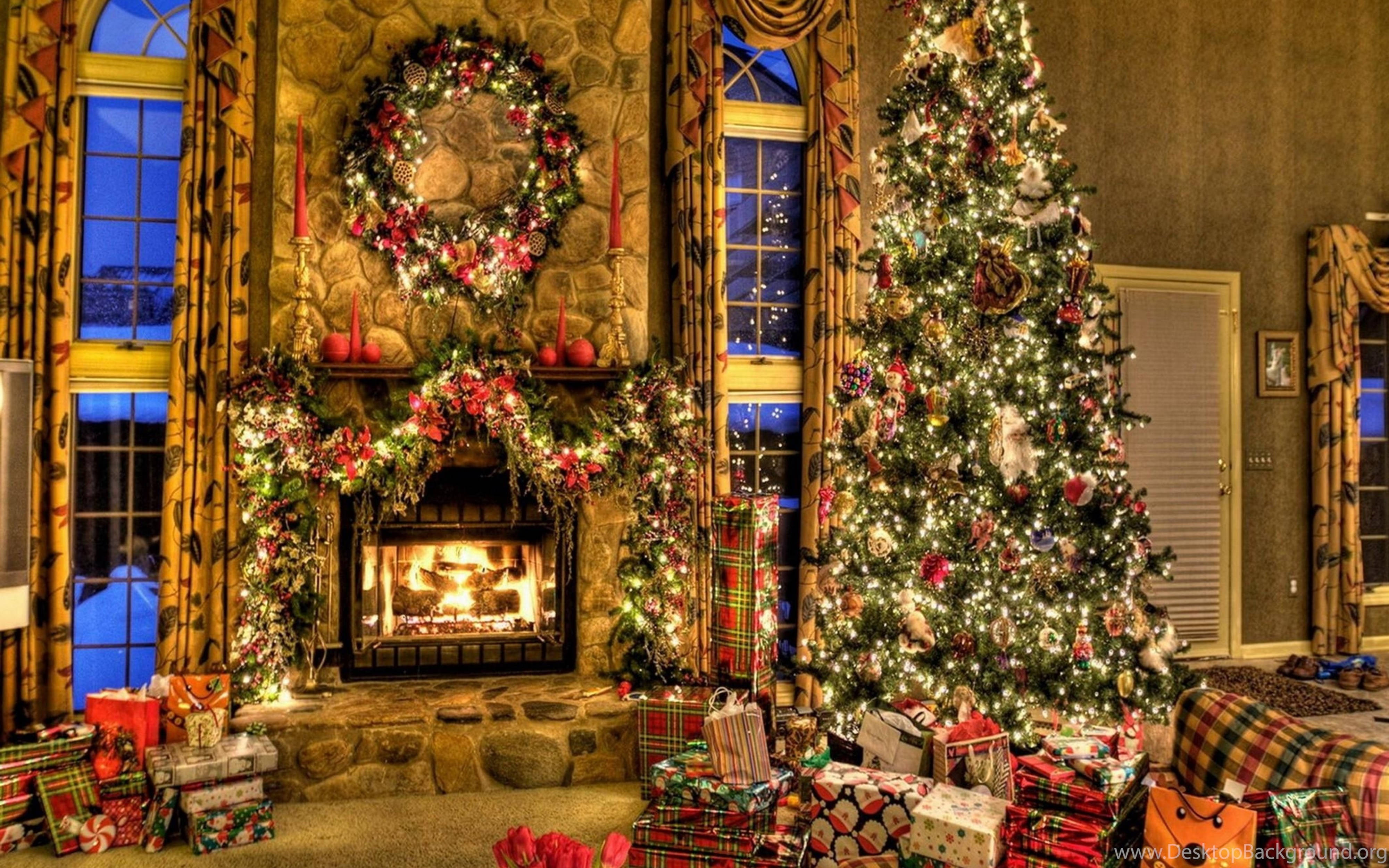 Christmas Presents 桌布 壁紙 — 一個溫暖照明的石壁爐裝飾著節日花環和花圈，旁邊是一棵高聳的聖誕樹，閃爍著燈光，周圍環繞著包裝好的禮物。
