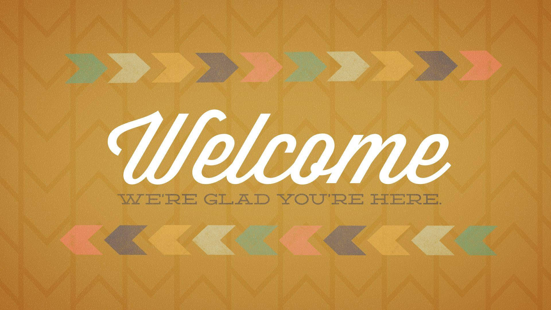 Welcome 桌布 壁紙 — 一個溫暖的橙色背景，帶有鋸齒形圖案和彩色箭頭，框住了以優雅白色字體書寫的「Welcome」一詞。