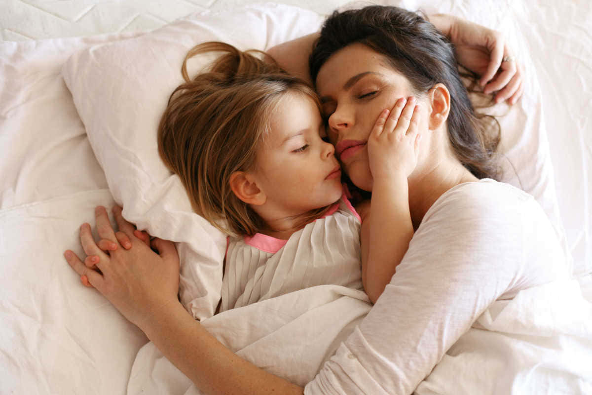 Mother Love 桌布 壁紙 — 一個溫柔的時刻，小女孩在柔和光線的臥室裡與母親一起安然入睡。