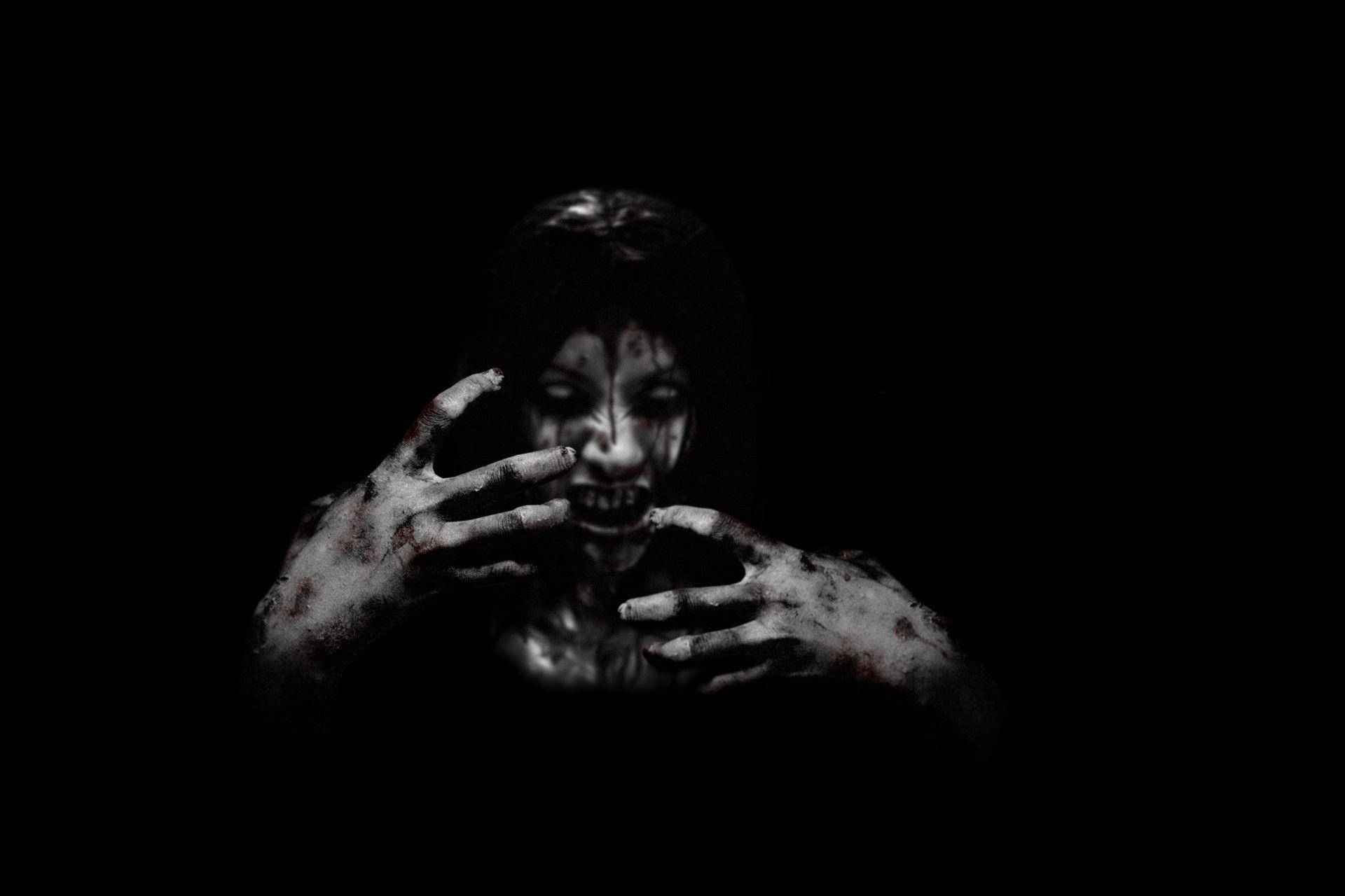 horror villains 桌布 壁紙 — 一個滿手鮮血、滿臉血污的恐怖人物從黑暗中浮現，呈現令人毛骨悚然的特寫。